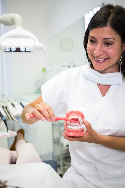 Zahnarzt zeigt dem Patienten, wie man Zähne putzt