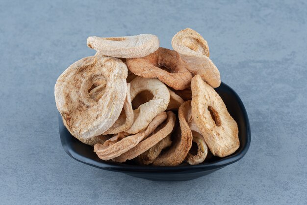 Zahniger trockener Apfel in der Schüssel auf dem Marmortisch.