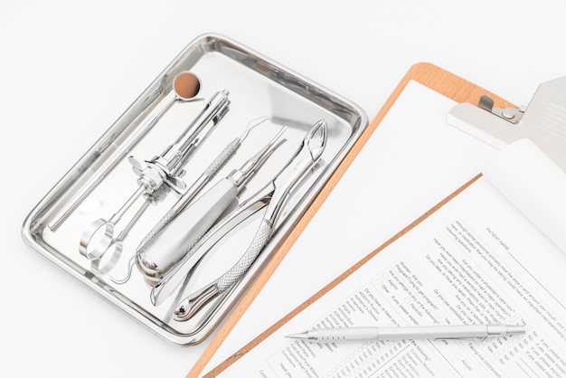 Zahnmedizinische Werkzeuge, Ausrüstung und zahnmedizinische Diagramm auf weißem Hintergrund