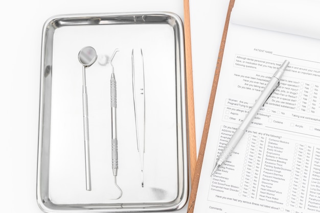 Zahnmedizinische Werkzeuge, Ausrüstung und zahnmedizinische Diagramm auf weißem Hintergrund