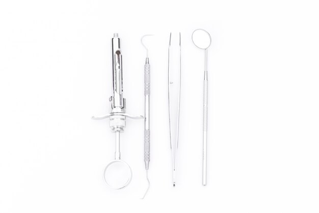 Zahnmedizinische Werkzeuge und Ausrüstung auf weißem Hintergrund.