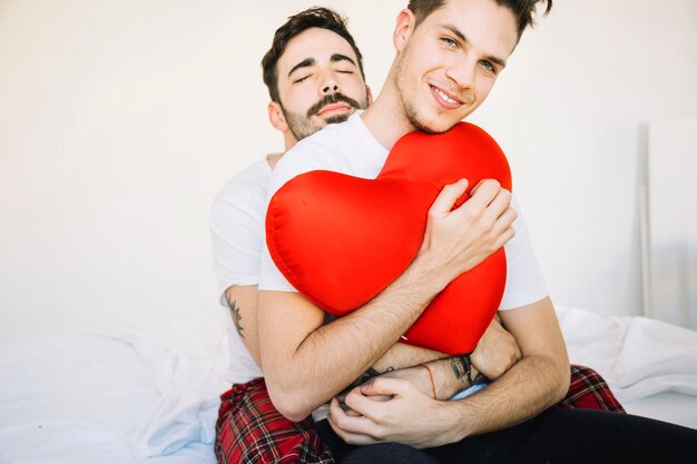 Zarte homosexuelle Paare, die auf Bett umfassen