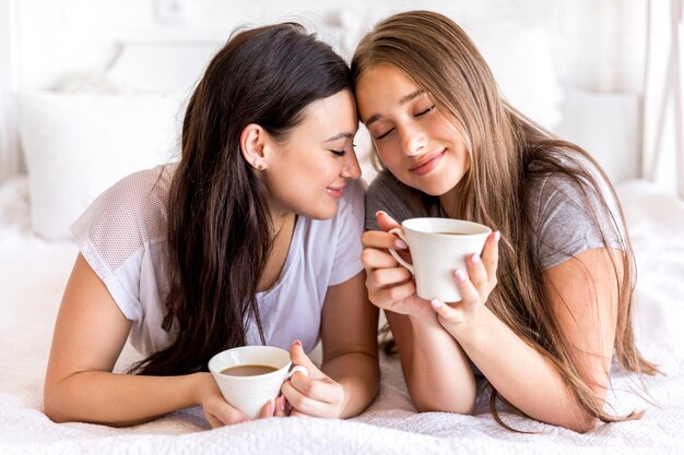 Zarte Paare mit Kaffee auf dem Bett