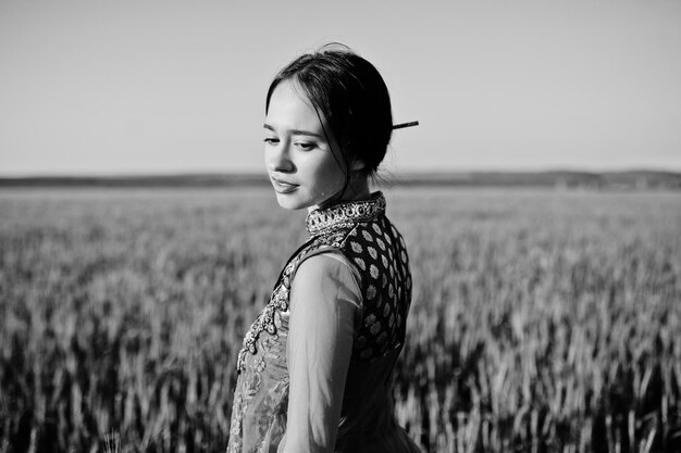 Zartes indisches Mädchen in Saree mit violetten Lippen Make-up bei Sonnenuntergang auf dem Feld gestellt Modisches Indien-Modell