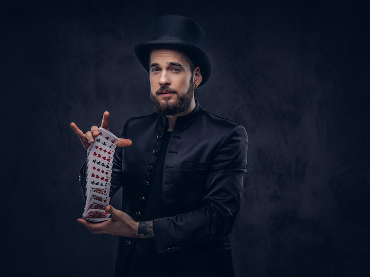 Kostenlose Foto zauberer zeigt trick mit spielkarten auf dunklem hintergrund.