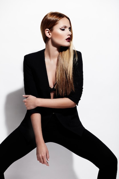 Zauberporträt des schönen sexy stilvollen kaukasischen modells der jungen frau im schwarzen stoff mit hellem make-up