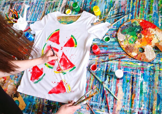 Premium Foto Zeichnen Auf Kleidung Madchen Zeichnet Auf Ein Weisses T Shirt