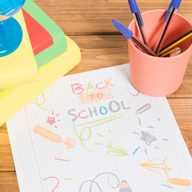 Zeichnen durch Farben auf Papier zurück zu Schule auf Holztisch mit Büchern und Bleistiften