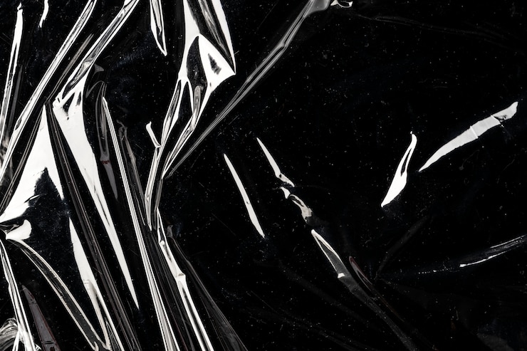 Kostenlose Foto zerknitterte plastikfolie textur auf einem schwarzen hintergrundbild