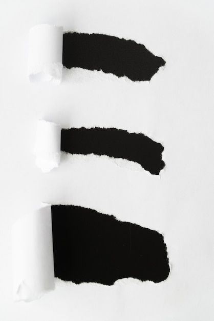 Zerrissenes Papier, das Schwarz enthüllt