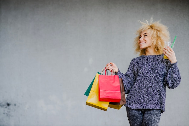 Kostenloses Foto ziemlich lässig mädchen mit taschen und getränk