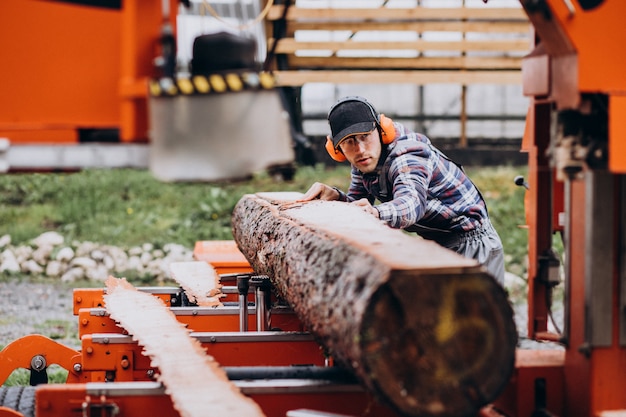 Kostenloses Foto zimmermann, der an einem sägewerk auf einer holzmanufaktur arbeitet