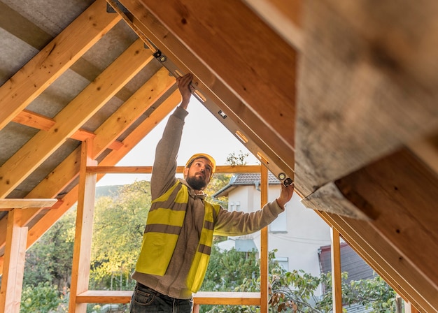 Kostenloses Foto zimmermannmann, der auf einem dach arbeitet