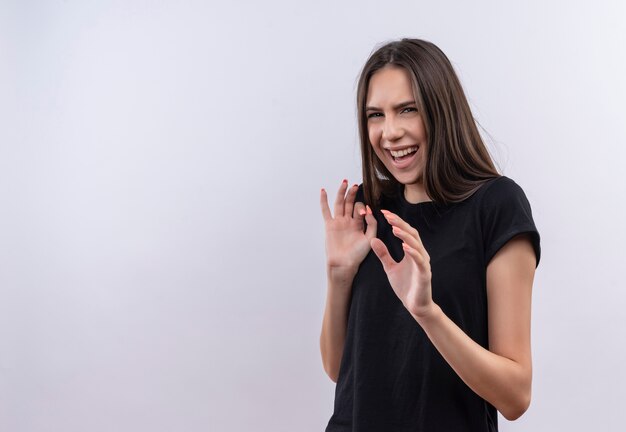 Zimperliches junges kaukasisches Mädchen, das schwarzes T-Shirt auf lokalisiertem weißem Hintergrund trägt