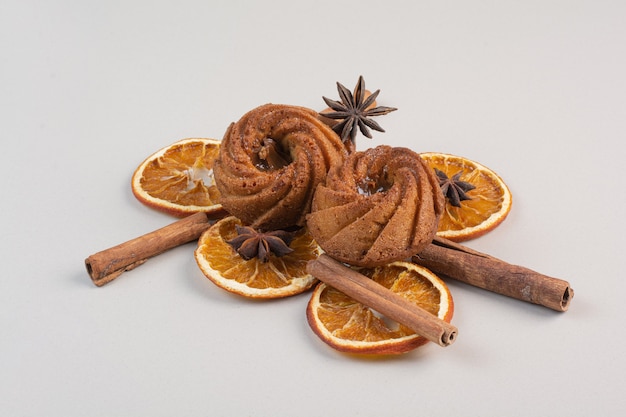 Zimtkuchen mit Orangenscheiben und Zimt auf weißer Oberfläche