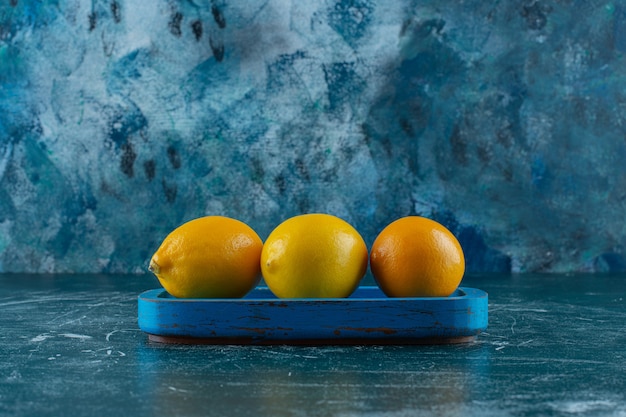Zitronen auf einer Holzplatte, auf dem Marmortisch.