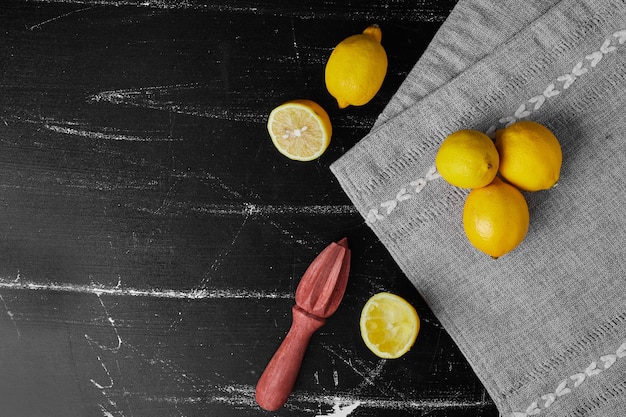 Zitronen lokalisiert auf einem schwarzen Hintergrund auf einem grauen Handtuch.