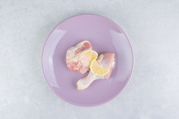 Zitronen- und Hühnerfleisch auf dem Teller auf der Marmoroberfläche