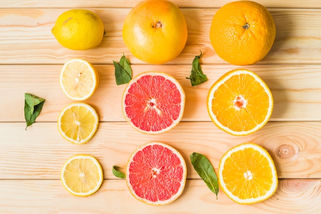 Kostenloses Foto zitronenscheiben; grapefruit und orange auf hölzernen hintergrund