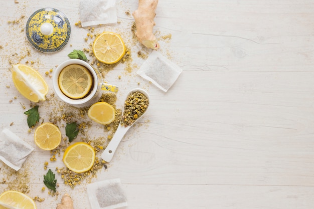 Zitronentee mit getrockneten chinesischen Chrysanthemenblumen und Zitronenscheiben auf Holztisch