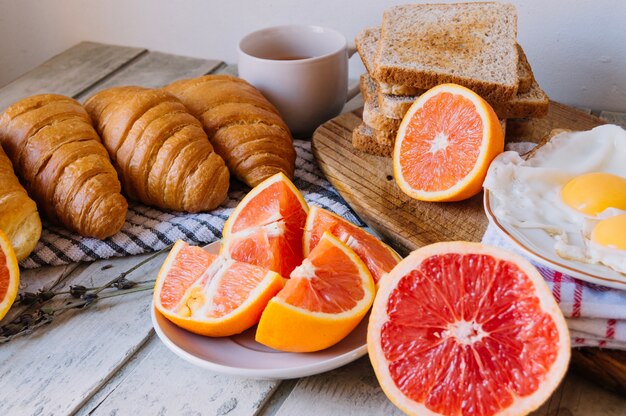 Zitrusfrüchte serviert mit Croissants