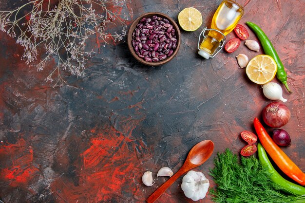 Zubereitung des Abendessens mit Ölflaschenbohnen, Zitrone und einem Haufen Grün auf einem Tisch mit gemischten Farben