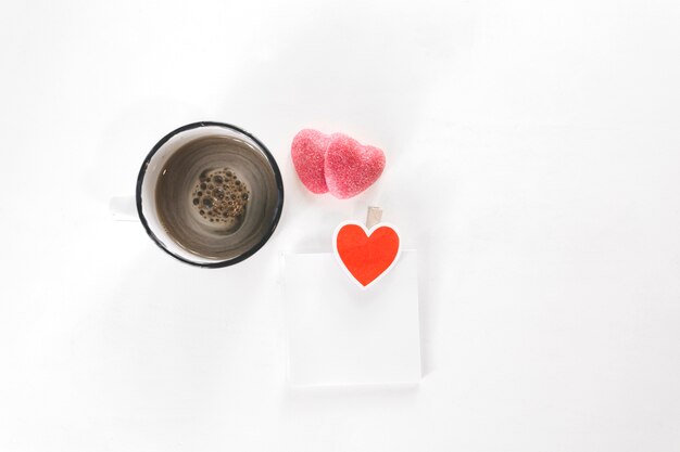 Zuckerherzen nahe Kaffee und klebriger Anmerkung