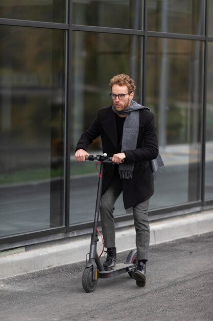 Zufälliger Mann, der mit einem Elektroroller aufwirft