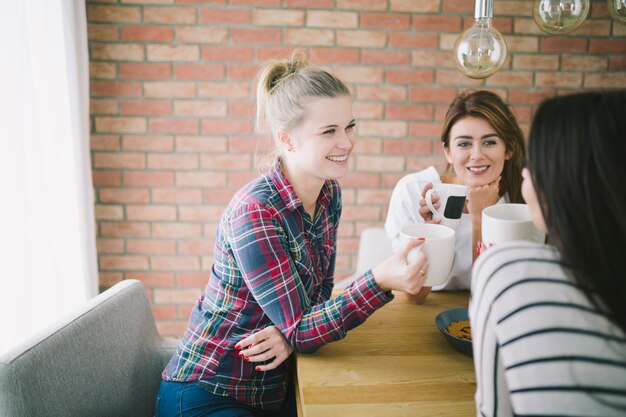 Zufriedene Frauen, die mit Tee sich entspannen