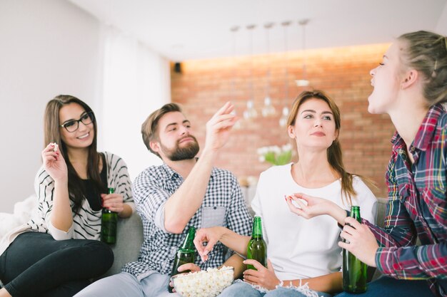 Zufriedene Freunde spielen und trinken Bier