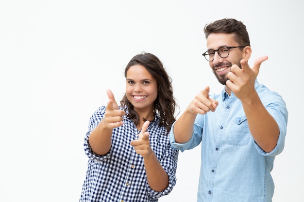 Zufriedene junge Paare, die Fingergewehre zeigen