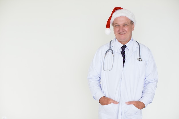 Zufriedener Doktor in Santa Hat mit den Händen in den Taschen
