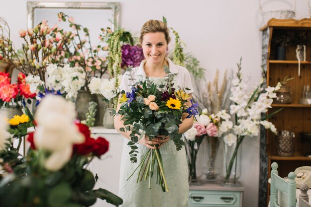 Zufriedener Florist, der bereiten Blumenstrauß zeigt