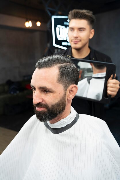 Zufriedener Kunde und Friseur mittlerer Schuss