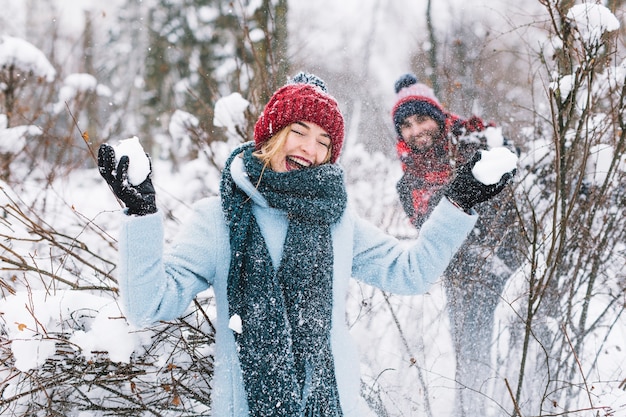 Zufriedener Mann und Frau, die Schneebälle spielen