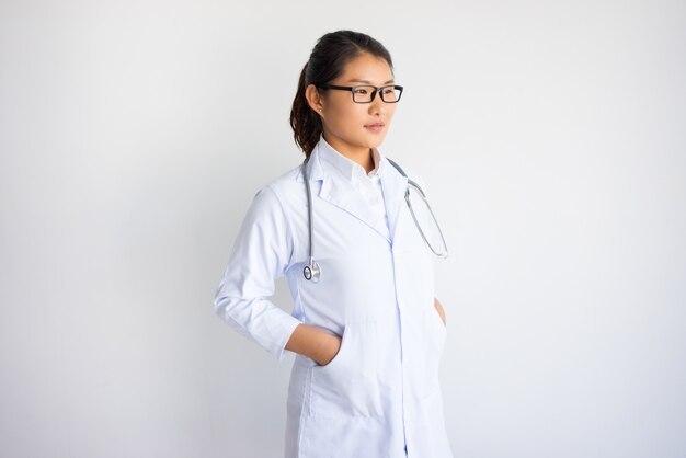 Zufriedener recht junger asiatischer weiblicher Doktor.