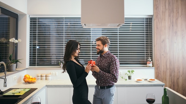 Kostenloses Foto zufriedenes paar mit geschenk in der küche