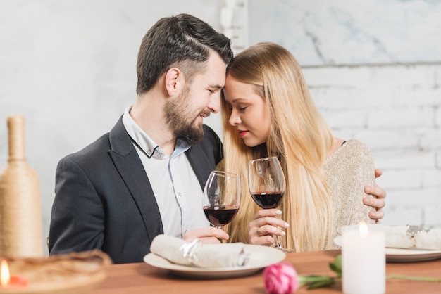 Zufriedenes Paar verliebt in Weingläser