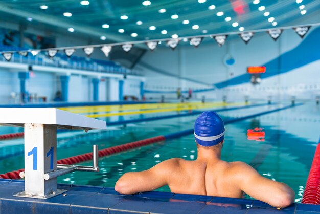 Zurück vom männlichen Schwimmer, der im Pool steht