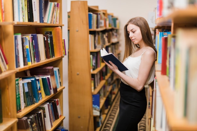 Kostenloses Foto zurück zu schulkonzept mit der frau, die in der bibliothek studiert