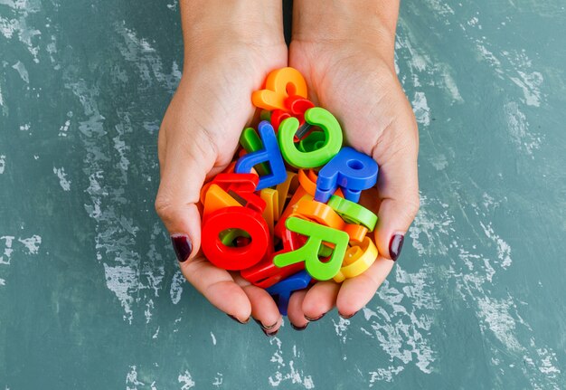 Zurück zum Schulkonzept. Frau, die bunte Buchstaben hält.