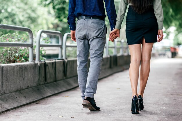 Zusammen. Abgeschnittene Aufnahme eines schönen, gut gekleideten Paares, das im Freien spazieren geht. Liebe, Beziehung, Dating-Konzept. Rückansicht