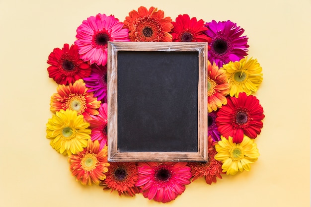 Kostenloses Foto zusammensetzung der tafel und der hellen blumen