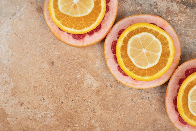 Zusammensetzung der Zitronen- und Grapefruitscheiben auf Marmorhintergrund.