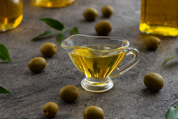 Zusammenstellung des Olivenöls in den Glas- und grünen Oliven