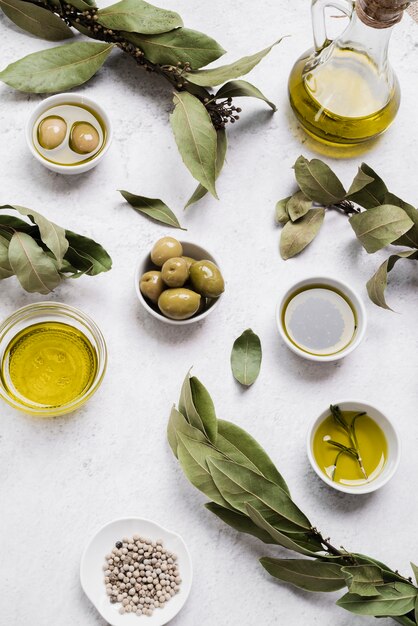 Zusammenstellung des Olivenöls und der Oliven auf dem Tisch