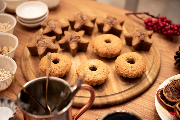 Zusammenstellung von Plätzchen auf hölzernem Brett mit winterberry