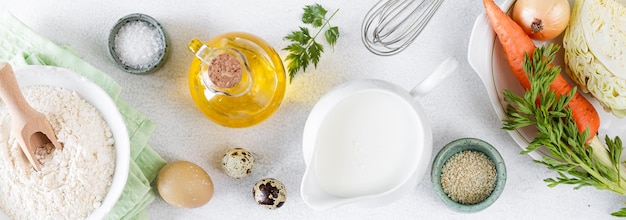 Kostenloses Foto zutaten für kohl- und karottenkuchen kohl karotten eier mehl milch butter gewürze auf weißem hintergrund