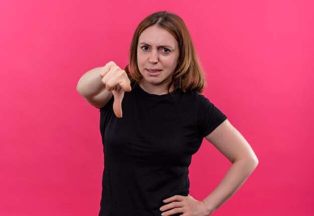 Zuversichtlich junge lässige Frau, die mit Hand auf Taille auf isoliertem rosa Raum mit Kopienraum zeigt