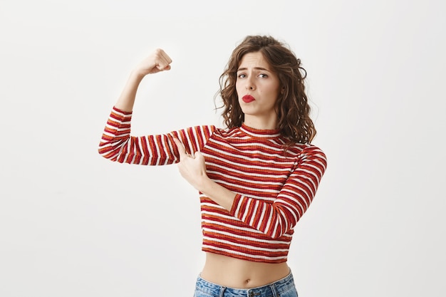 Zuversichtlich Mädchen Flex Bizeps, zeigen Muskeln nach dem Fitnessstudio